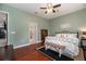 Inviting bedroom with hardwood flooring, comfortable bedding, a bench, and views of the en-suite bathroom at 5155 Lake Deeson Woods Ct, Lakeland, FL 33805