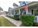 Inviting front porch with white columns, lush landscaping, and a charming American flag at 5155 Lake Deeson Woods Ct, Lakeland, FL 33805