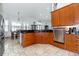 Open kitchen with wood cabinets, black countertops, stainless steel appliances, and breakfast nook with natural light at 5155 Lake Deeson Woods Ct, Lakeland, FL 33805
