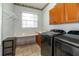 The laundry room with side by side washer and dryer, tile floors, and storage space at 5155 Lake Deeson Woods Ct, Lakeland, FL 33805