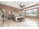 Spacious primary bedroom featuring a tray ceiling, large windows, neutral decor, and tile flooring at 5155 Lake Deeson Woods Ct, Lakeland, FL 33805