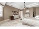 Inviting main bedroom showcasing a tray ceiling, decorative fan, natural paint, and tiled floors at 5155 Lake Deeson Woods Ct, Lakeland, FL 33805
