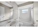 Bright bathroom features white tile, chrome hardware, a single sink vanity and a tub with shower at 519 Eagle Ct, Kissimmee, FL 34759