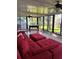 Bright sunroom with a large red couch and wall-to-wall sliding glass doors at 528 Laurel Ln, Lakeland, FL 33813