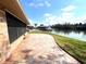 A paved patio provides outdoor relaxation space with a view of the lake and dock at 600 Caribbean Dr, Lakeland, FL 33803