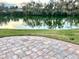 An expansive lake view enhances the outdoor experience from the brick paved patio at 600 Caribbean Dr, Lakeland, FL 33803