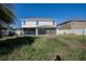 View of the home's backyard showing the covered patio, lush lawn, and privacy fence at 6011 Placid Pass, Lakeland, FL 33805