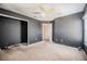 Bedroom featuring neutral carpet, a closet, gray walls, a ceiling fan, and an entrance to the hallway at 6011 Placid Pass, Lakeland, FL 33805