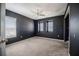 Modern bedroom featuring dark walls, plush carpeting, and a ceiling fan for comfort at 6011 Placid Pass, Lakeland, FL 33805