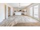 Bright, open kitchen boasts an island, stainless appliances, white cabinetry, and light wood-look flooring at 6011 Placid Pass, Lakeland, FL 33805