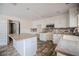 Bright kitchen with white cabinets, stone countertops, an island, and stainless steel appliances at 6011 Placid Pass, Lakeland, FL 33805
