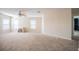 Spacious living room with neutral carpet, a ceiling fan, and lots of natural light from the windows at 6011 Placid Pass, Lakeland, FL 33805