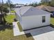 Aerial view showcasing a newly constructed home's rear elevation, concrete driveway, and grassy yard at 629 7Th W St, Lakeland, FL 33805