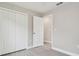 Bedroom with gray vinyl flooring, white closet doors and access to additional room at 629 7Th W St, Lakeland, FL 33805