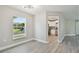 Dining area with gray vinyl flooring, neutral walls, and a view of the kitchen at 629 7Th W St, Lakeland, FL 33805