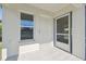 Front entrance with white door, screen door and window, and concrete flooring at 629 7Th W St, Lakeland, FL 33805