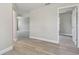 Hallway with gray vinyl flooring, neutral walls, and access to other rooms at 629 7Th W St, Lakeland, FL 33805