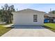 Rear view of house with concrete driveway and lawn at 629 7Th W St, Lakeland, FL 33805