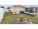 A tranquil backyard with a lanai, mature landscaping and a view of the property at 6610 Crescent Loop, Winter Haven, FL 33884