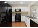 Stylish kitchen featuring granite countertops, black appliances, and white cabinetry at 6610 Crescent Loop, Winter Haven, FL 33884