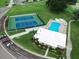 Aerial view of community tennis courts and pool, with lush landscaping and parking at 6962 Starmount Dr, Lakeland, FL 33810