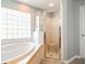 Bathroom featuring a soaking tub, glass block window, and a glass shower enclosure at 6962 Starmount Dr, Lakeland, FL 33810