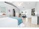 Bright bedroom with neutral walls, tile floors, white furnishings, and a blue throw blanket at 6962 Starmount Dr, Lakeland, FL 33810