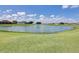 Scenic pond view with lush green surroundings and clear blue skies enhancing the property's tranquil ambiance at 6962 Starmount Dr, Lakeland, FL 33810