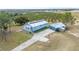 Aerial view of home with a deck, large driveway, metal roof, and solar panels at 705 Lake Ada Blvd, Dundee, FL 33838