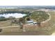 Aerial view of home and property with lake access, large lawn and well-maintained landscaping at 705 Lake Ada Blvd, Dundee, FL 33838