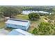 Aerial view of home with a metal roof, solar panels, a nice yard and nearby lake at 705 Lake Ada Blvd, Dundee, FL 33838