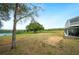 Spacious backyard with a large tree perfect for a hammock, overlooking a beautiful lake at 705 Lake Ada Blvd, Dundee, FL 33838