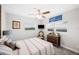 Cozy bedroom featuring light gray walls, wood-look ceiling fan and a bright picture window for natural light at 705 Lake Ada Blvd, Dundee, FL 33838