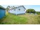 Side view of home with a well-maintained lawn, partial view of the lake and privacy fence at 705 Lake Ada Blvd, Dundee, FL 33838