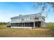 Back exterior of home with solar panels and a screened-in porch, overlooking a beautiful field at 705 Lake Ada Blvd, Dundee, FL 33838