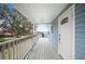 Inviting front porch with wood flooring, white railings, and flower boxes for added charm at 705 Lake Ada Blvd, Dundee, FL 33838