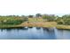 Scenic lake view showcasing the waterfront with home in the distance surrounded by lush trees at 705 Lake Ada Blvd, Dundee, FL 33838
