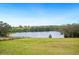 Scenic view of a tranquil pond surrounded by lush greenery and a clear blue sky at 705 Lake Ada Blvd, Dundee, FL 33838