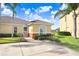 Charming yellow home with a tile roof, complemented by lush green grass and manicured bushes, creating a serene and inviting curb appeal at 116 Ocean Bluff Dr # 116, Kissimmee, FL 34759