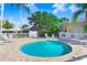 Outdoor pool with lounge chairs, surrounded by lush landscaping and clear blue skies at 116 Ocean Bluff Dr # 116, Kissimmee, FL 34759