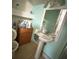 Small bathroom with turquoise walls, standard toilet, cabinet storage, and pedestal sink at 118 S 5Th St, Haines City, FL 33844