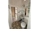 Bathroom with patterned tile flooring, standard toilet, and small white sink at 118 S 5Th St, Haines City, FL 33844