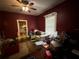 Bedroom featuring red walls, ceiling fan, a neutral trim and doorway to the kitchen at 118 S 5Th St, Haines City, FL 33844