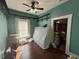 Bedroom showcases laminate floors, a ceiling fan and shelving surrounding a sunlit window at 118 S 5Th St, Haines City, FL 33844