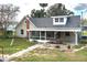 Back exterior of the home with a screened porch, brick chimney, and mature trees at 1290 S Mcadoo Ave, Bartow, FL 33830