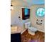 Bathroom with granite-topped vanity, wood-look flooring and unique octagon window at 1290 S Mcadoo Ave, Bartow, FL 33830