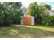 Backyard shed with a wooden double-door and surrounding green grass at 1290 S Mcadoo Ave, Bartow, FL 33830