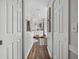 Hallway view into bathroom with double vanity and wood-look tile flooring at 1301 Hidden Creek Ct, Winter Haven, FL 33880