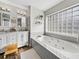 Bathroom featuring a double vanity, soaking tub, and natural light at 1301 Hidden Creek Ct, Winter Haven, FL 33880