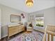 Bright Bedroom with chair, changing table and twin cribs, bathed in natural light at 1301 Hidden Creek Ct, Winter Haven, FL 33880